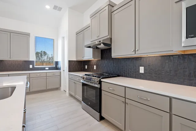 a kitchen with cabinets appliances a sink and a counter top space