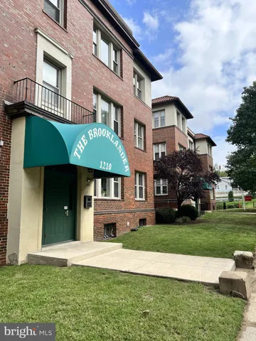 a view of a white house with a big yard and potted plants