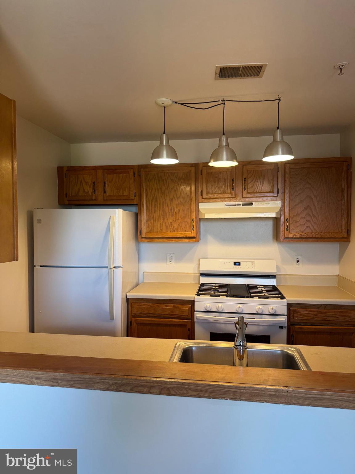 1210 Perry Street Northeast, Unit 202 Washington, DC 20017 - Photo 15 of 30 a kitchen with kitchen island a stove and a refrigerator