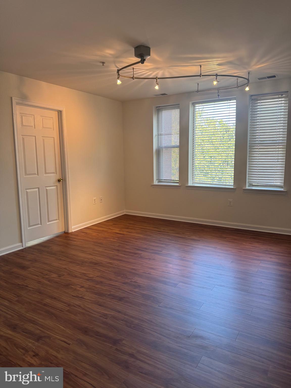 1210 Perry Street Northeast, Unit 202 Washington, DC 20017 - Photo 7 of 30 an empty room with wooden floor and windows