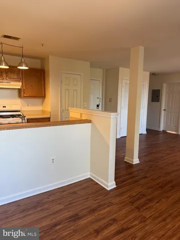 a view of a kitchen with wooden floor and a sink