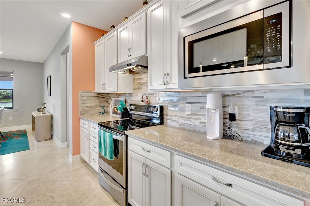11812 Clifton Terrace Fort Myers, FL 33913 - Photo 11 of 46 a kitchen with stainless steel appliances a stove microwave and sink
