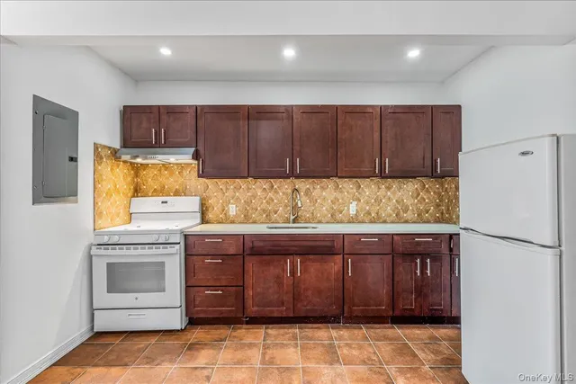 a kitchen with granite countertop a refrigerator and a stove top oven