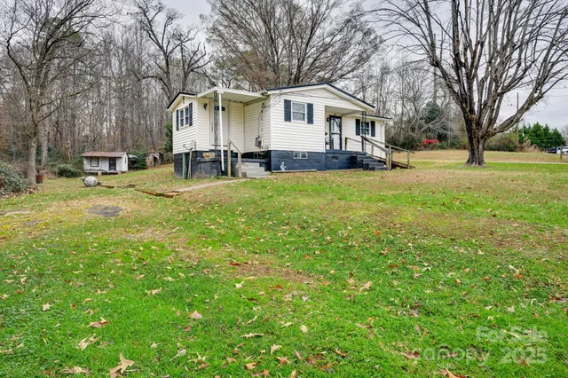 a front view of a house with a yard and trees