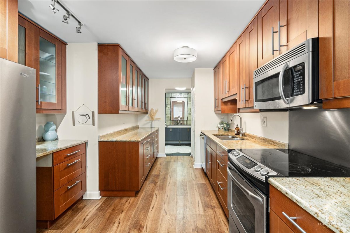 1405 East Central Road, Unit 222C Arlington Heights, IL 60005 - Photo 13 of 45 a kitchen with stainless steel appliances granite countertop a stove and a sink