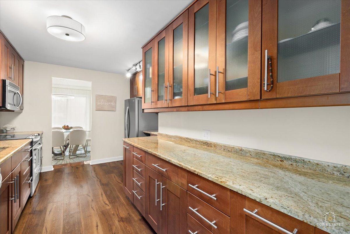 1405 East Central Road, Unit 222C Arlington Heights, IL 60005 - Photo 18 of 45 a hallway with sink and wooden cabinets