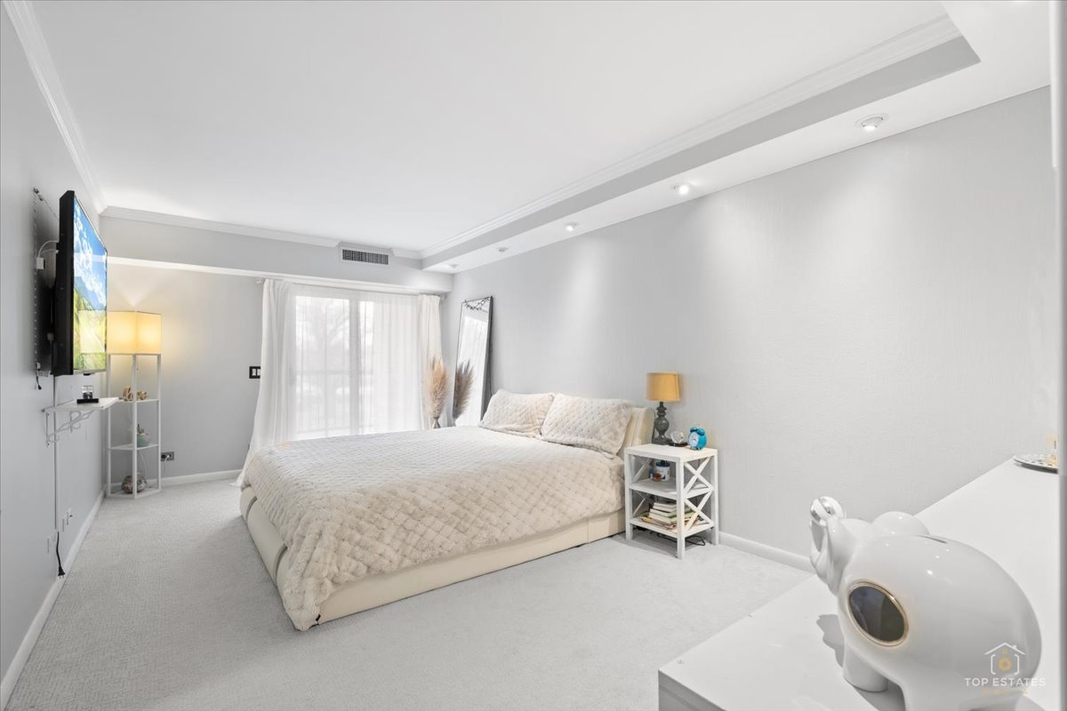 1405 East Central Road, Unit 222C Arlington Heights, IL 60005 - Photo 20 of 45 a bedroom with a bed and a couch