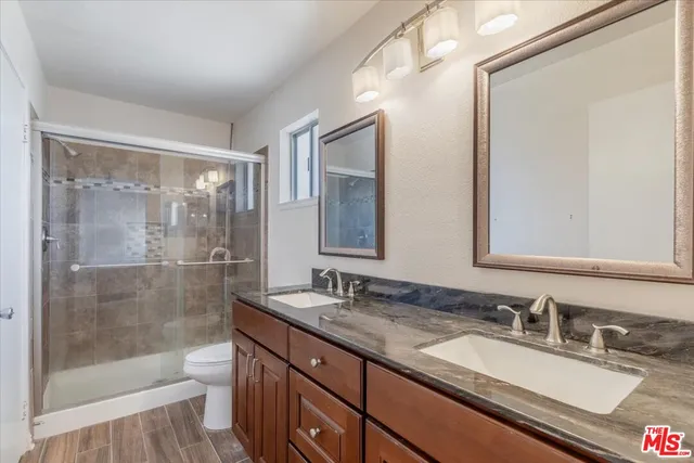 a bathroom with a granite countertop sink mirror toilet and bathtub