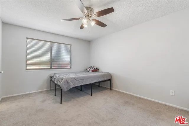 an empty room with a window and a ceiling fan