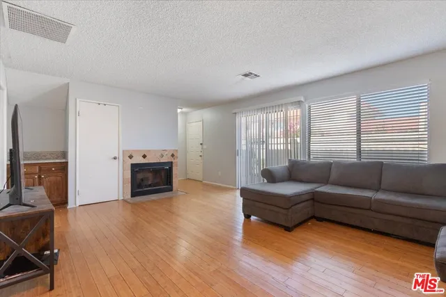 a living room with furniture a fireplace and a wooden floor