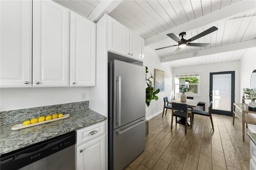 18018 East Armstead Street Azusa, CA 91702 - Photo 13 of 43 a kitchen with granite countertop a refrigerator a stove a dining table and chairs with wooden floor