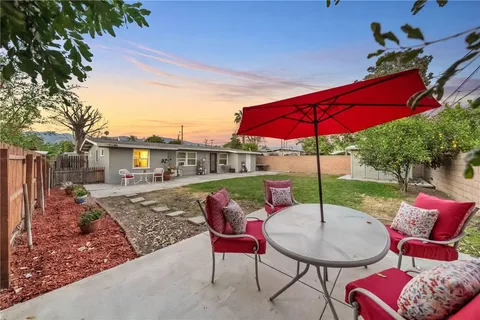 a balcony with furniture and red umbrella