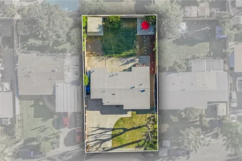 an aerial view of residential houses with outdoor space and trees