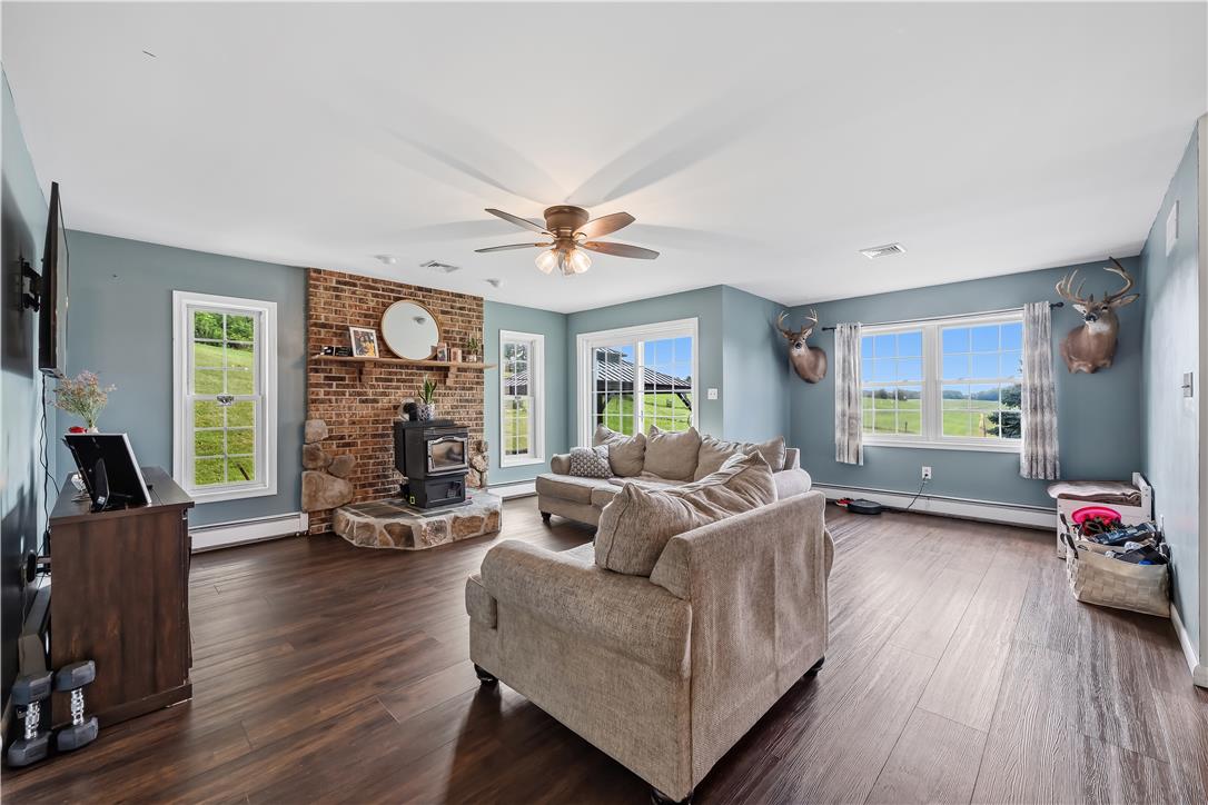 9868 Stagecoach Road Kempton, PA 19529 - Photo 7 of 17 Warm wood flooring extends throughout this generous living room, centered around a charming brick fireplace.