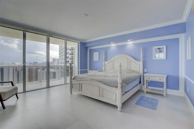 a bedroom with a bed and a large window with balcony view