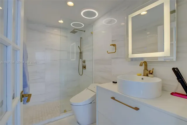 a bathroom with a sink mirror toilet and shower