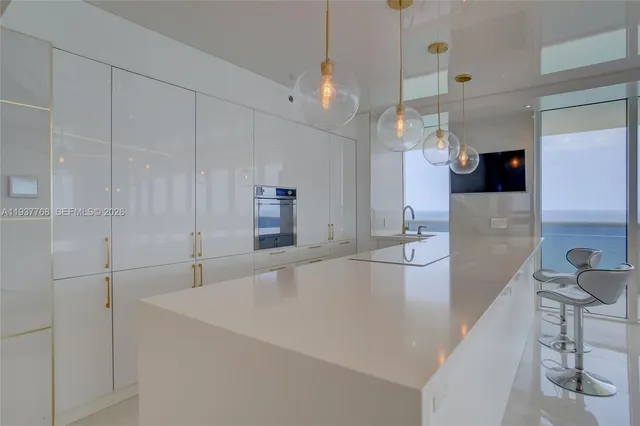 a large white kitchen with a large island