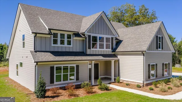 an aerial view of a house with swimming pool and large trees