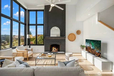 a living room with furniture fireplace and a large window