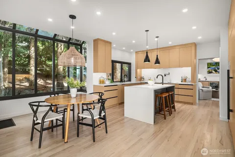 a kitchen with stainless steel appliances granite countertop a sink a stove a refrigerator and island with wooden floor