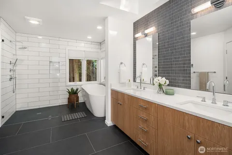 a white bath tub sitting in a bathroom next to a window