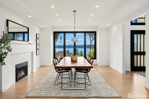 a dining room with furniture a fireplace and wooden floor