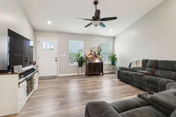 a kitchen with stainless steel appliances kitchen island granite countertop a white cabinets and chairs