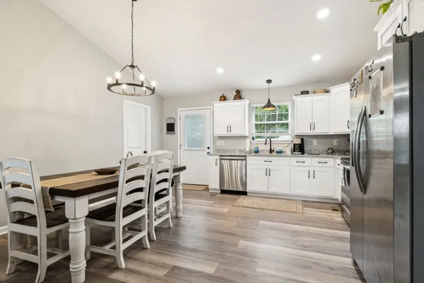 a kitchen with white cabinets and stainless steel appliances