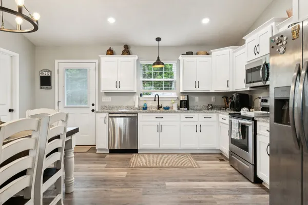 a view of kitchen with refrigerator and wooden floor