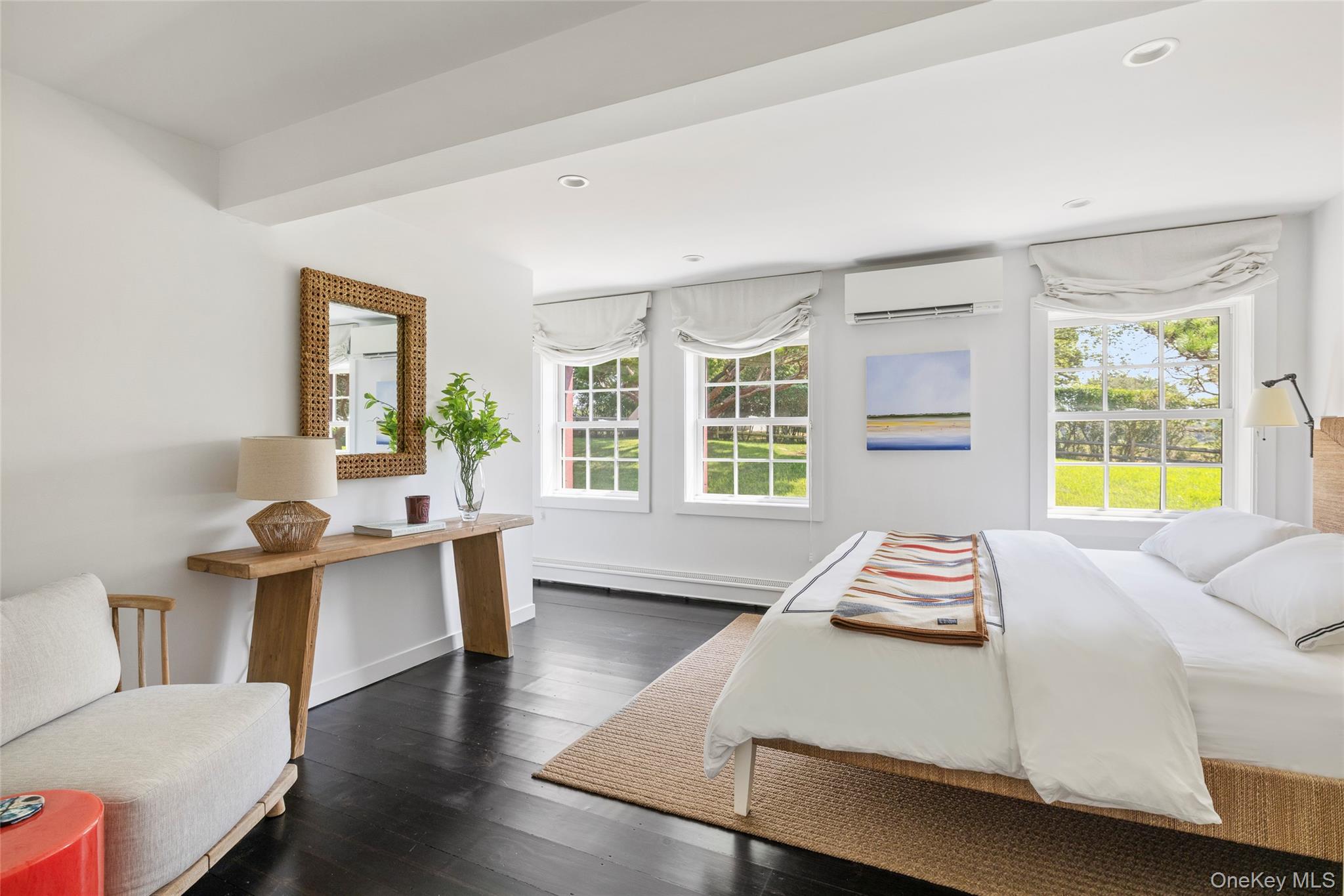 26 Ruxton Road East Hampton, NY 11937 - Photo 29 of 37 1st Floor Bedroom featuring multiple windows, dark wood-type flooring, a wall unit AC, recessed lighting, and a baseboard radiator