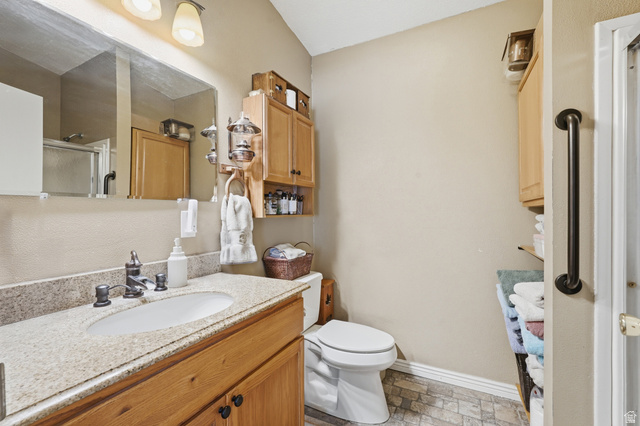 8066 North Valley View Heights Preston, ID 83263 - Photo 19 of 34 Vanity featuring a light-toned stone countertop, an undermount sink, and a dark-toned faucet
