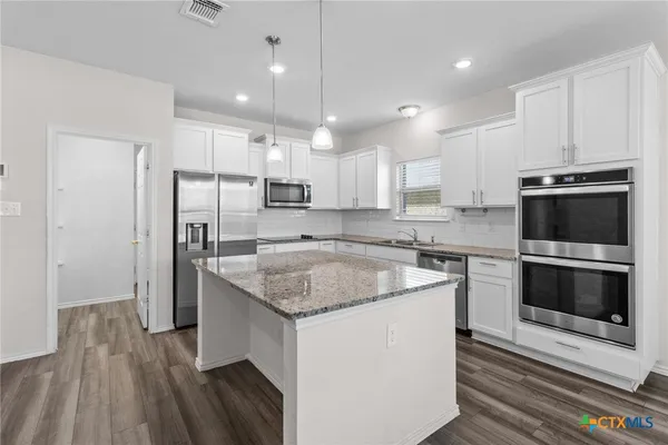 a kitchen with a sink stove and refrigerator