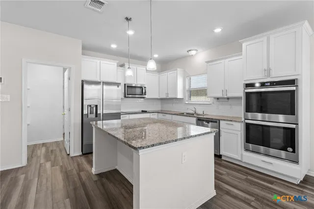 a kitchen with a sink stove and refrigerator