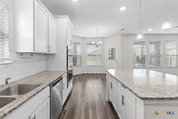 a kitchen with a sink stove and cabinets