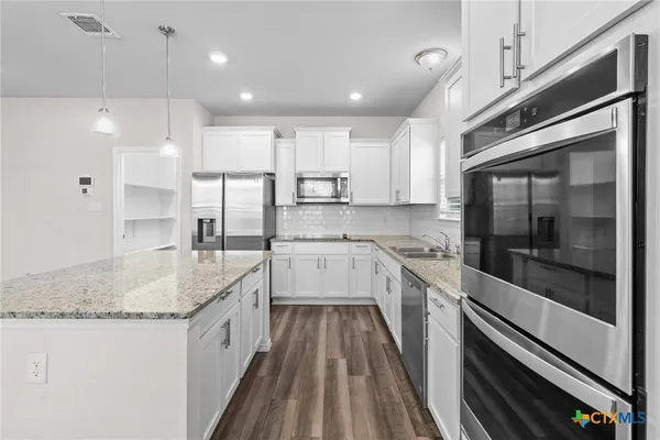 a kitchen with stainless steel appliances granite countertop a sink and a stove