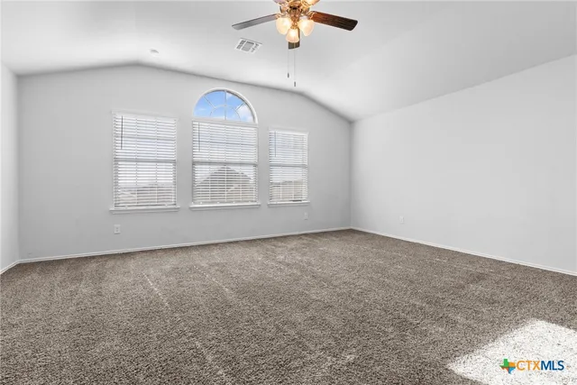 a view of an empty room with a ceiling fan