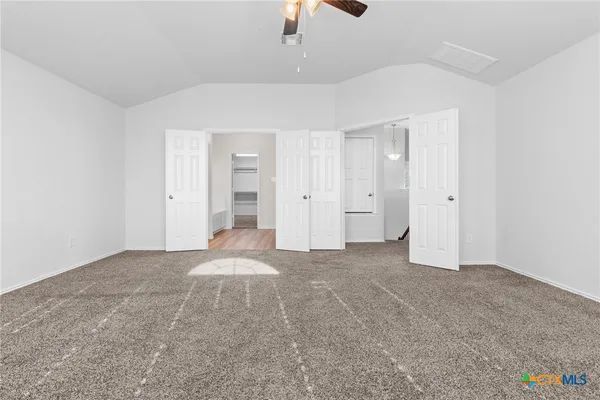 a view of an empty room with a ceiling fan