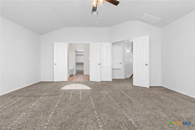 a view of an empty room with a ceiling fan