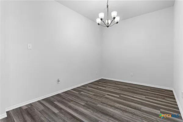 a view of a room with wooden floor and a ceiling fan
