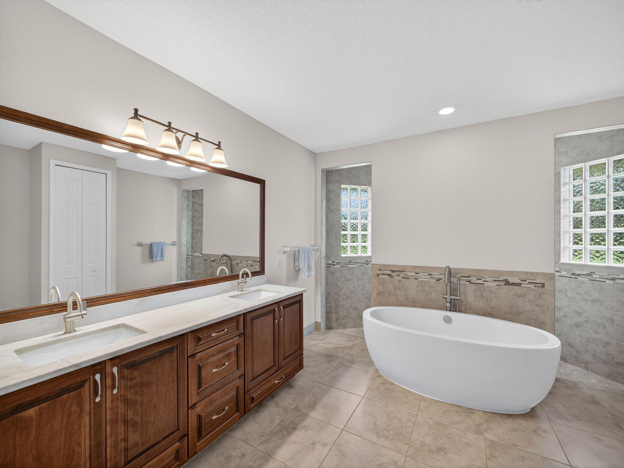 17593 Winterhawk Trail Jupiter, FL 33478 - Photo 20 of 49 a bathroom with a double vanity sink tub and mirror