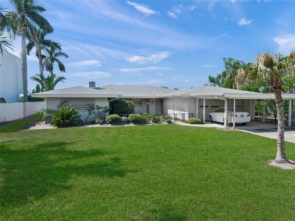 1386 Tangier Way Sarasota, FL 34239 - Photo 9 of 26 a front view of a house with a yard table and chairs