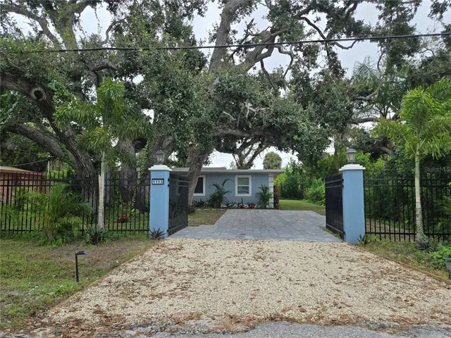 a front view of a house with a yard and tree