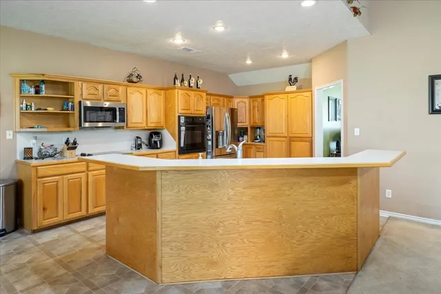 a kitchen with stainless steel appliances a refrigerator a sink dishwasher with a stove and cabinets