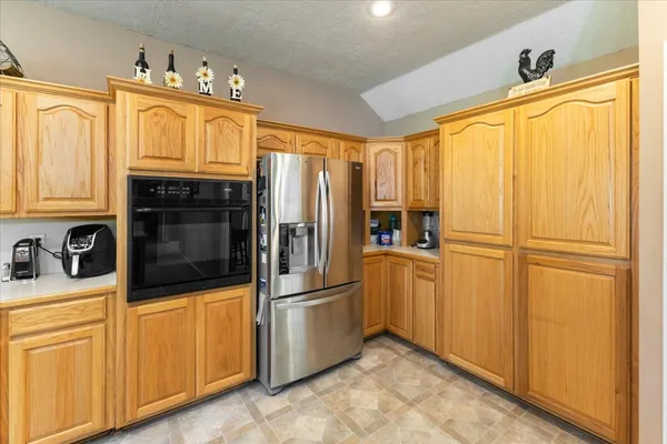 a kitchen with stainless steel appliances granite countertop a refrigerator a microwave and cabinets
