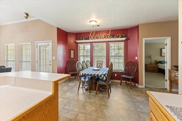 a dining hall with couches a dining table and chairs with wooden floor