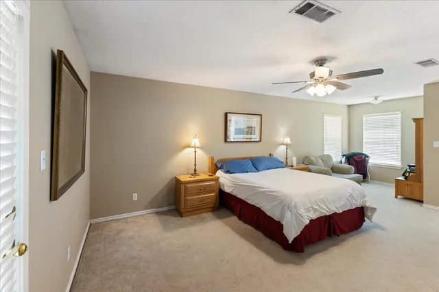 a spacious bedroom with a bed and a chandelier