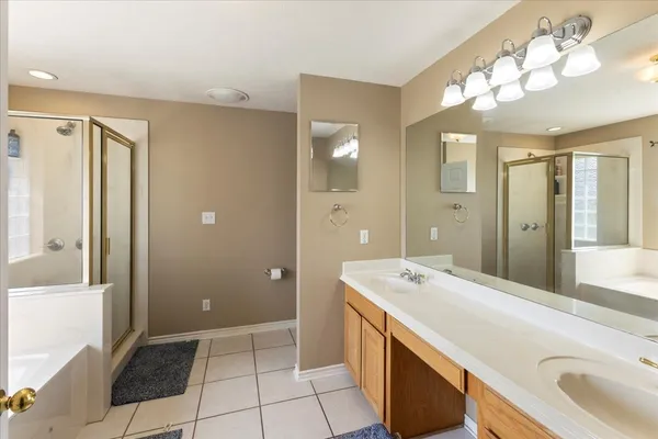 a spacious bathroom with a shower sink and mirror