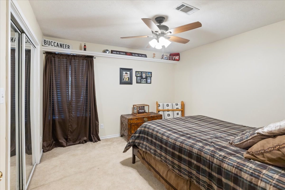 544 Meadow Lane Winnie, TX 77665 - Photo 34 of 38 a bedroom with a large bed and a chandelier