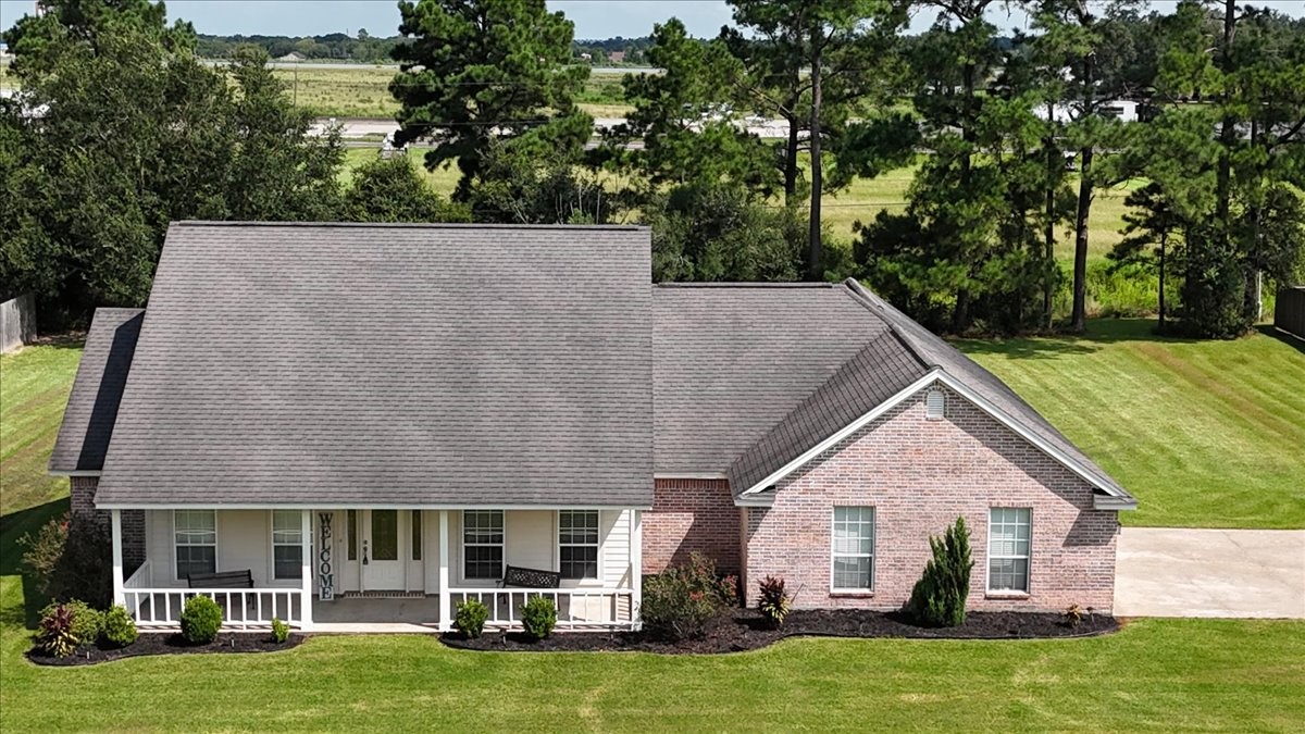 544 Meadow Lane Winnie, TX 77665 - Photo 9 of 38 a view of a white house with a big yard and large trees