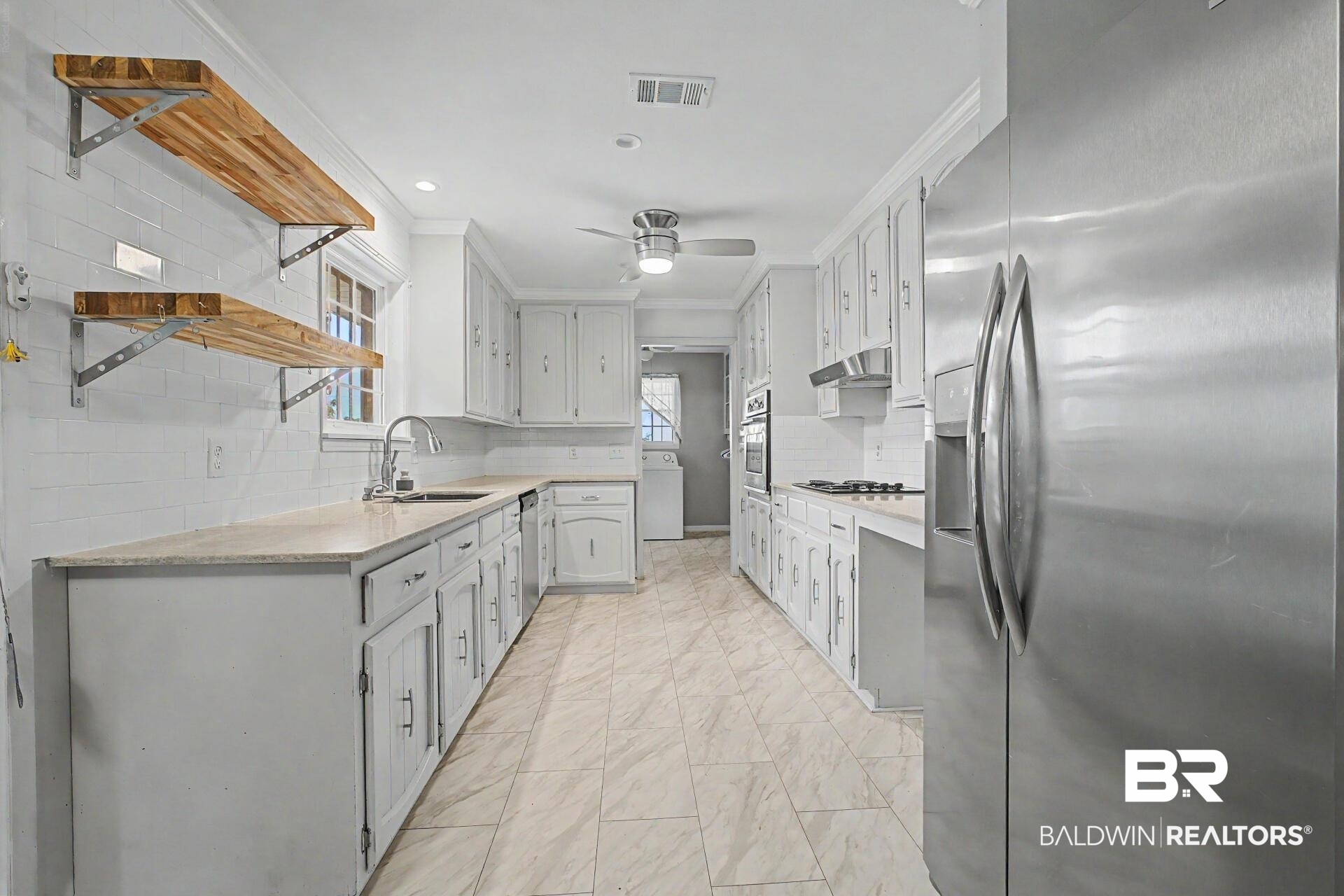 3791 Robinsonville Road Atmore, AL 36502 - Photo 24 of 47 Galley kitchen featuring light-toned cabinetry, light-toned countertops, a full suite of stainless steel appliances, and tiled flooring